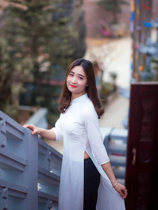 a woman is standing on a metal fence