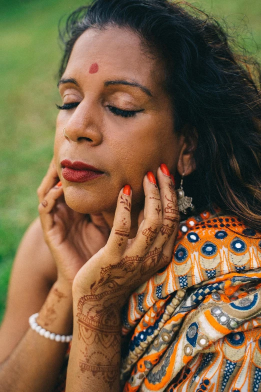 a woman sits with her hand on her chin