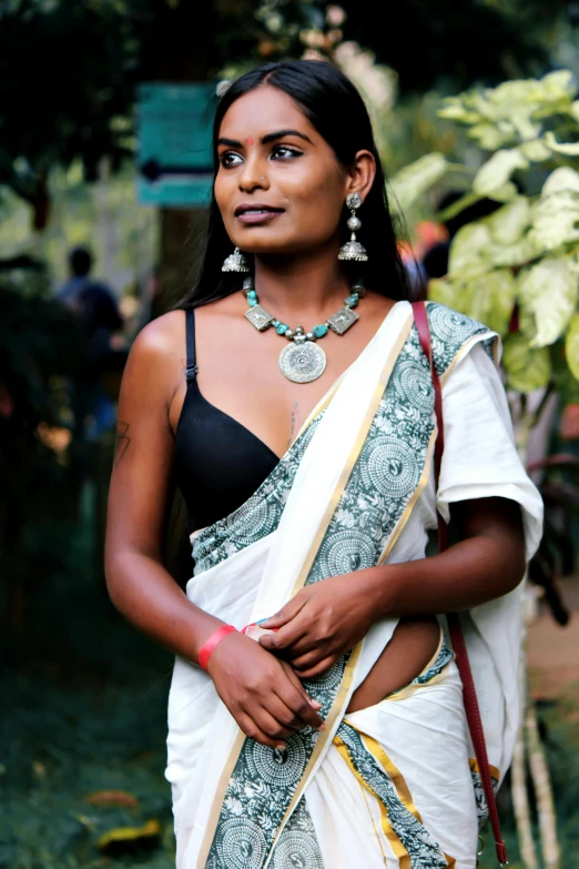 a woman wearing a saree and necklaces