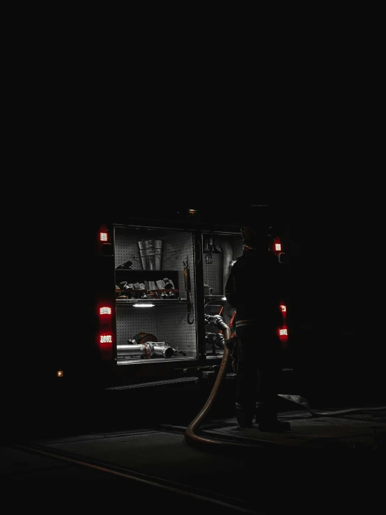 two firemen working in the dark by a truck