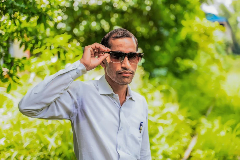 an old man in glasses and a shirt stands outside