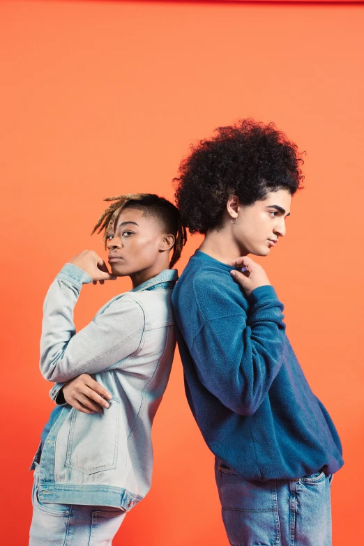 a couple of people standing up against a wall