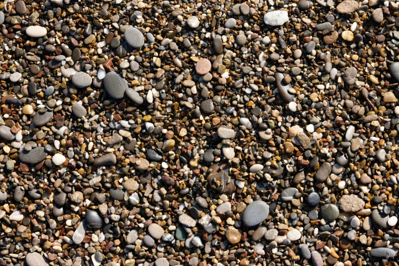 a bunch of different colors and sizes of rocks on gravel