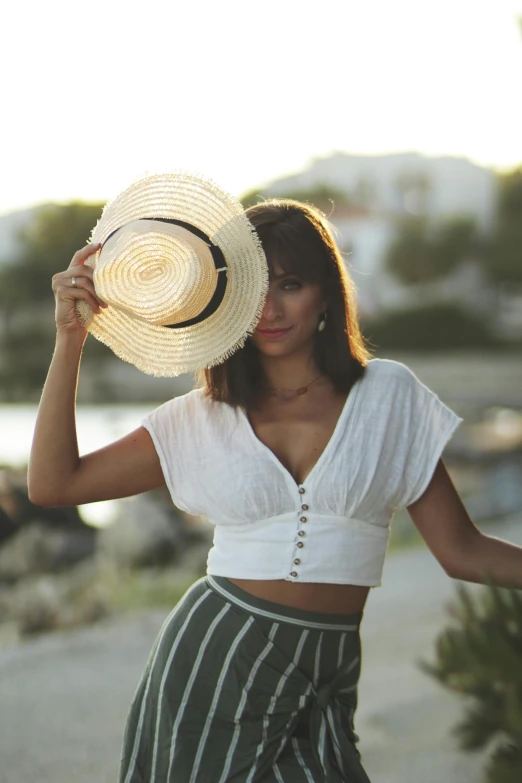 a woman with a white hat and striped skirt