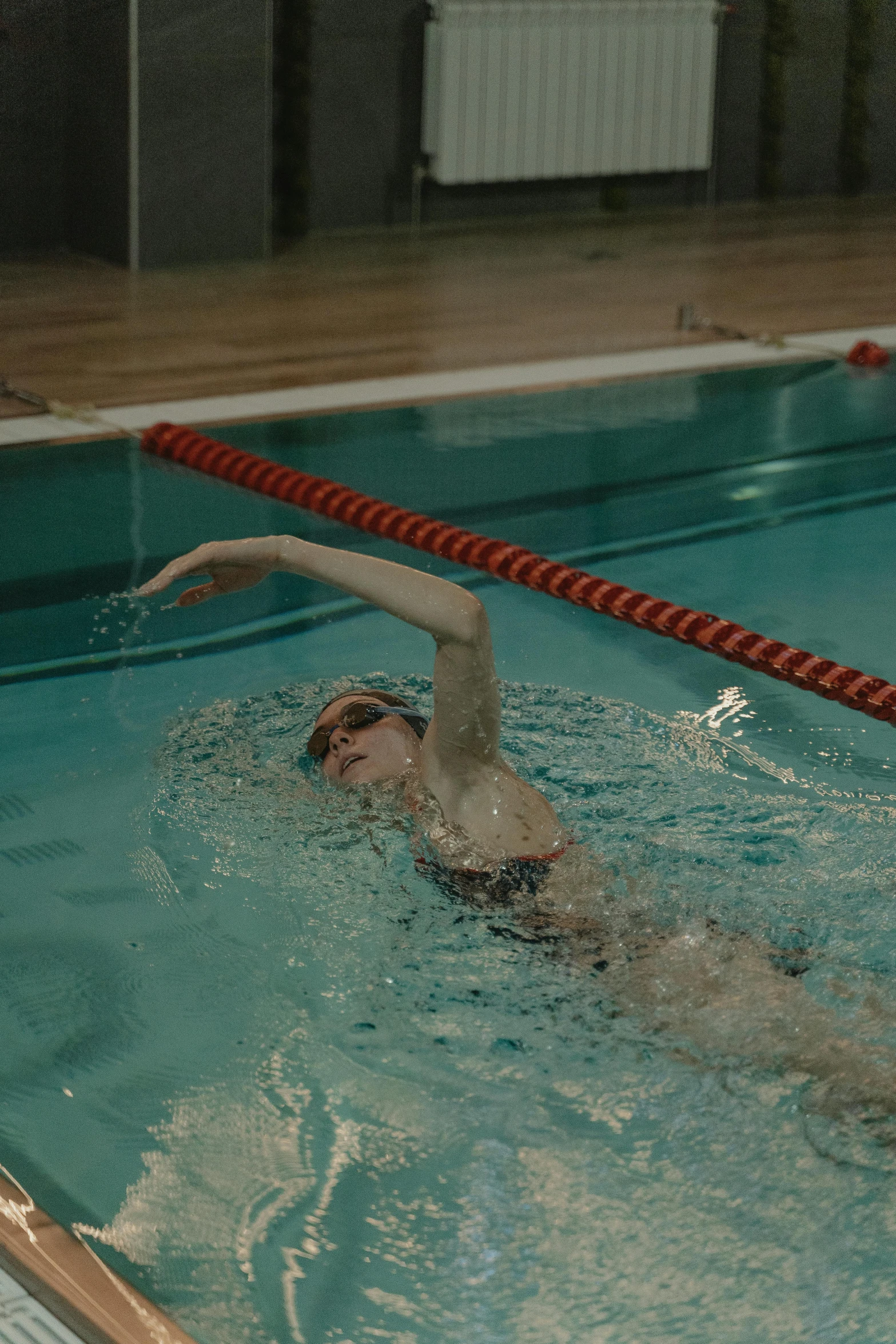 a man swimming in a pool on top of a blue board