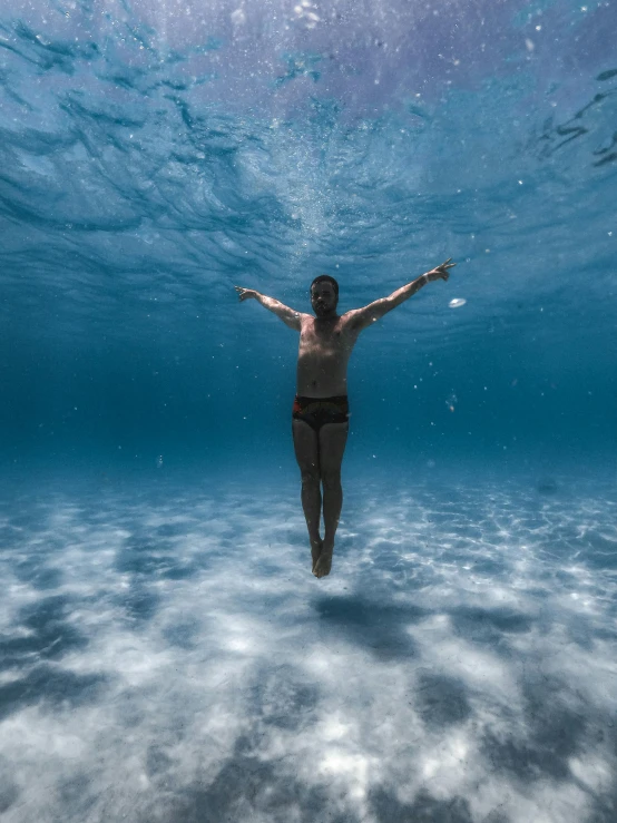 the man has his arms up underwater