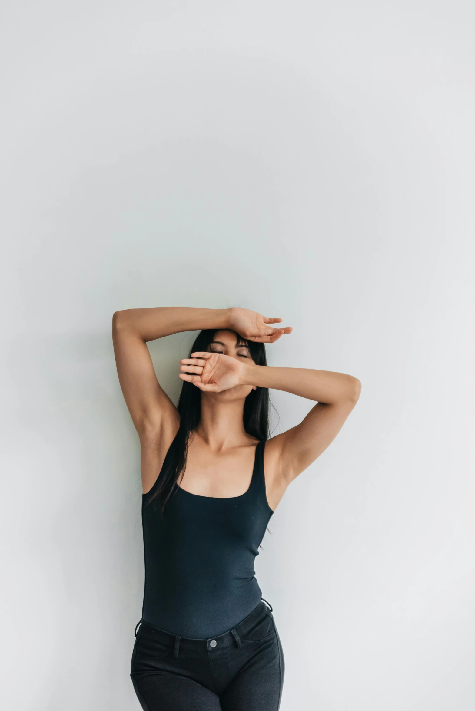 a young woman with her hands behind her head