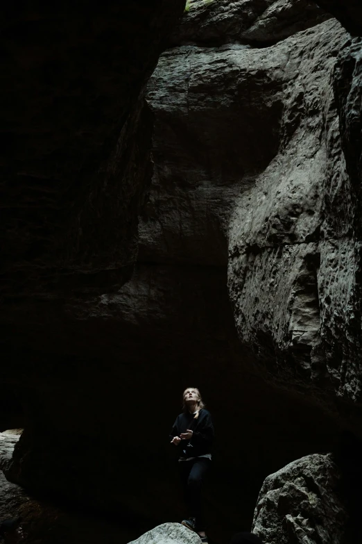 a person that is sitting down near rocks