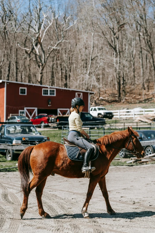 young woman riding on back of horse while it's walking