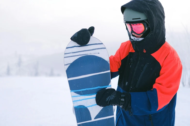 a person with a snowboard standing in the snow