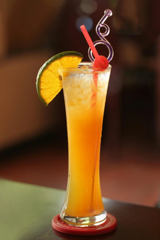 a glass with a drink and some garnish sitting on a table