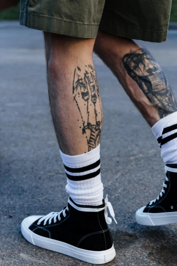 a man's legs with tattoos and his leg showing