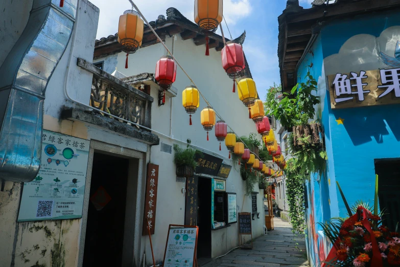 the small alleyway is lined with brightly colored lanterns