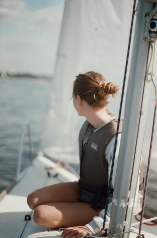 a girl sitting on the deck of a sailboat
