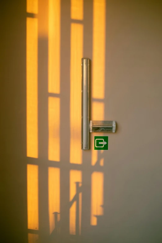 the shadow of a wall shows a metal door handle