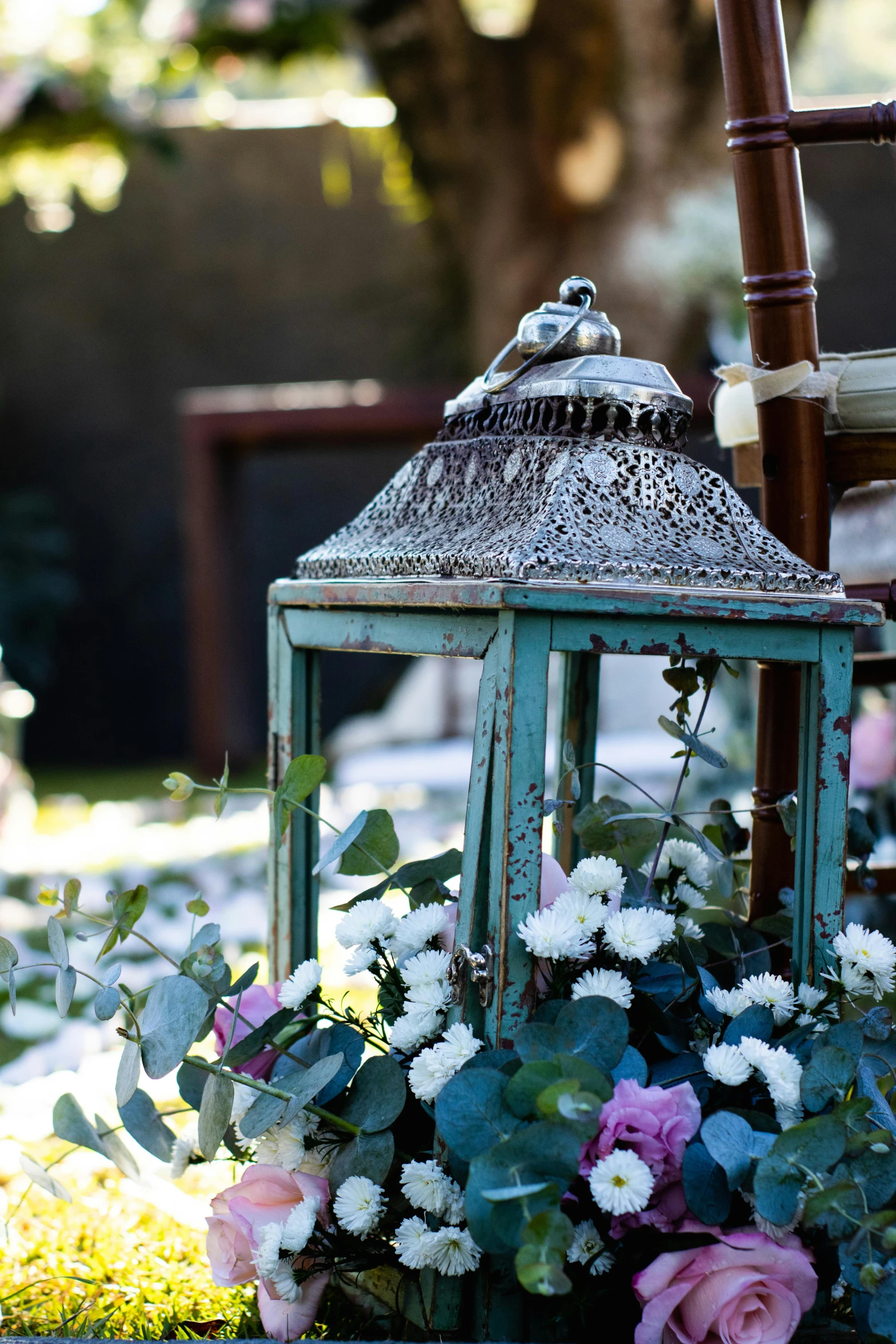 a lantern that is sitting next to some flowers