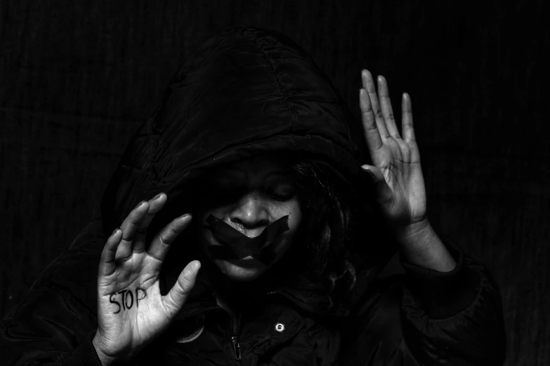 a clown with painted face and hands in front of black background