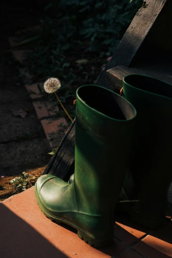a couple of green boots sitting on top of a brick road