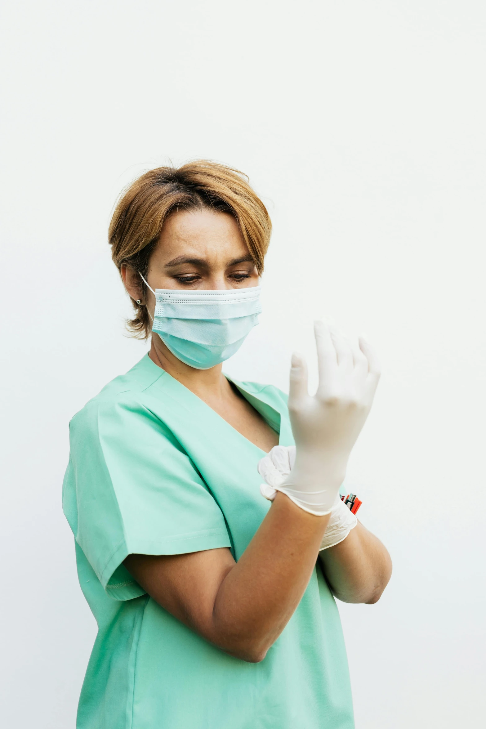 a female doctor wearing a green scrub and white gloves