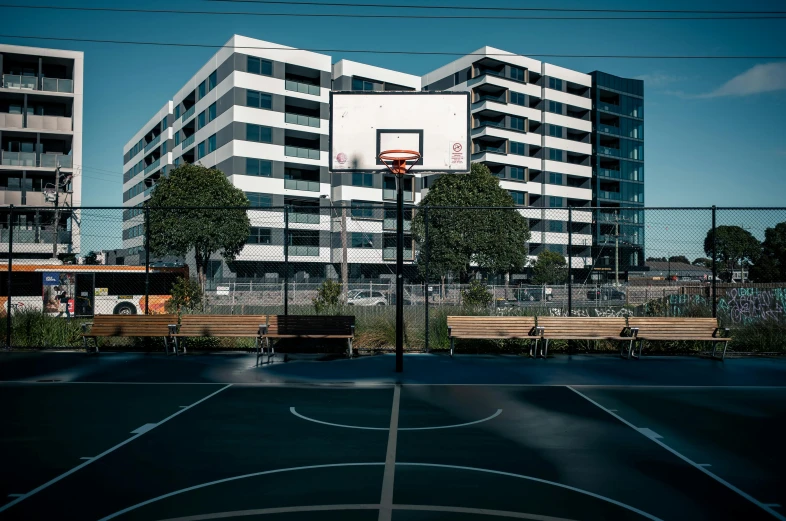 an empty basketball court surrounded by tall buildings