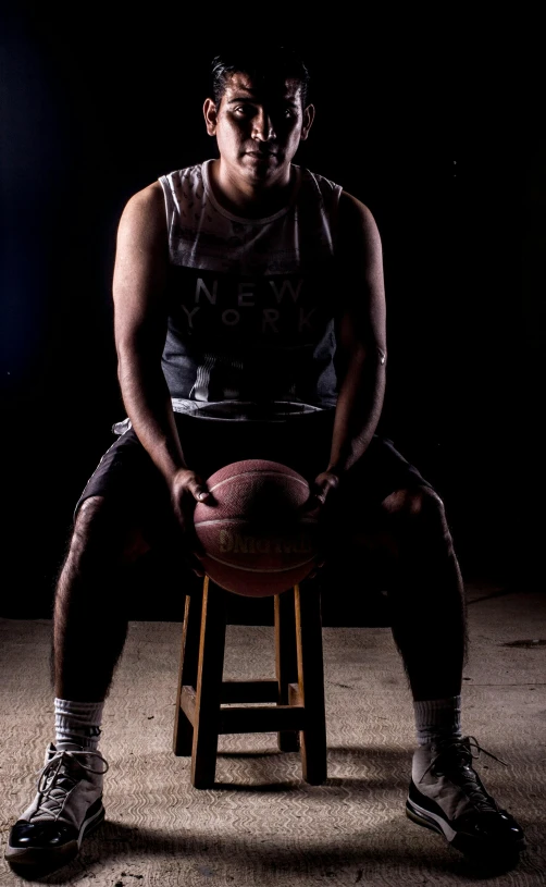 a man in a dark room holding a football