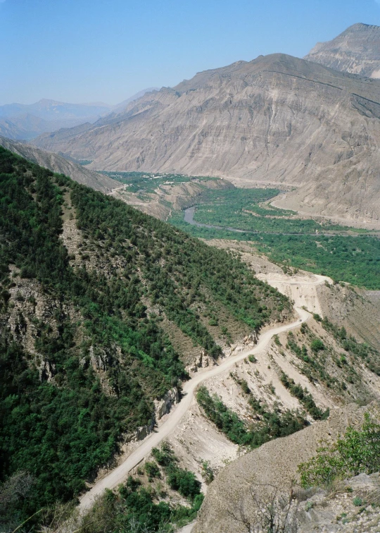 a truck on a dirt road by the side of a mountain