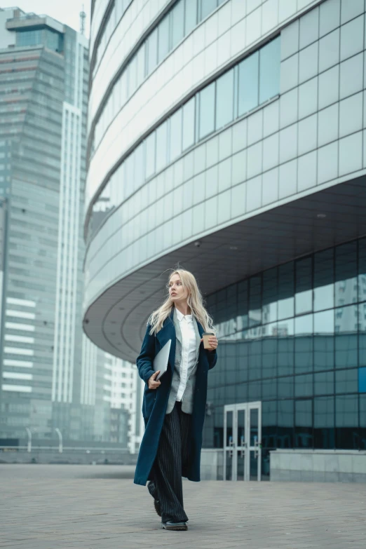 a woman with blond hair is standing in front of the building