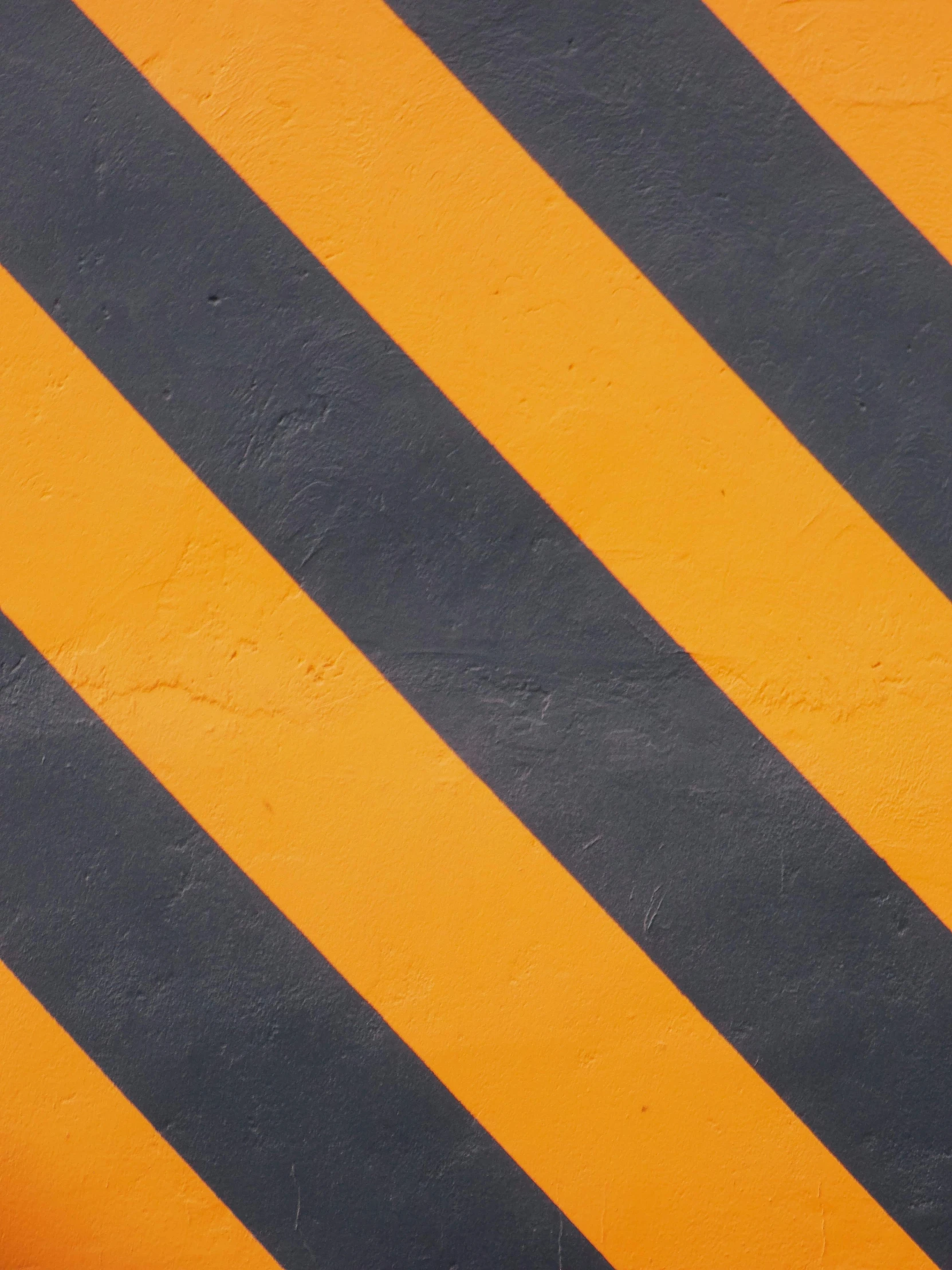 a black and yellow diagonal stripe next to the pavement