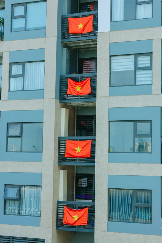 the windows on this building are decorated with red and yellow flags