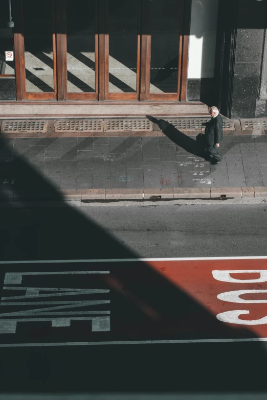 man walking down the street past the crosswalk