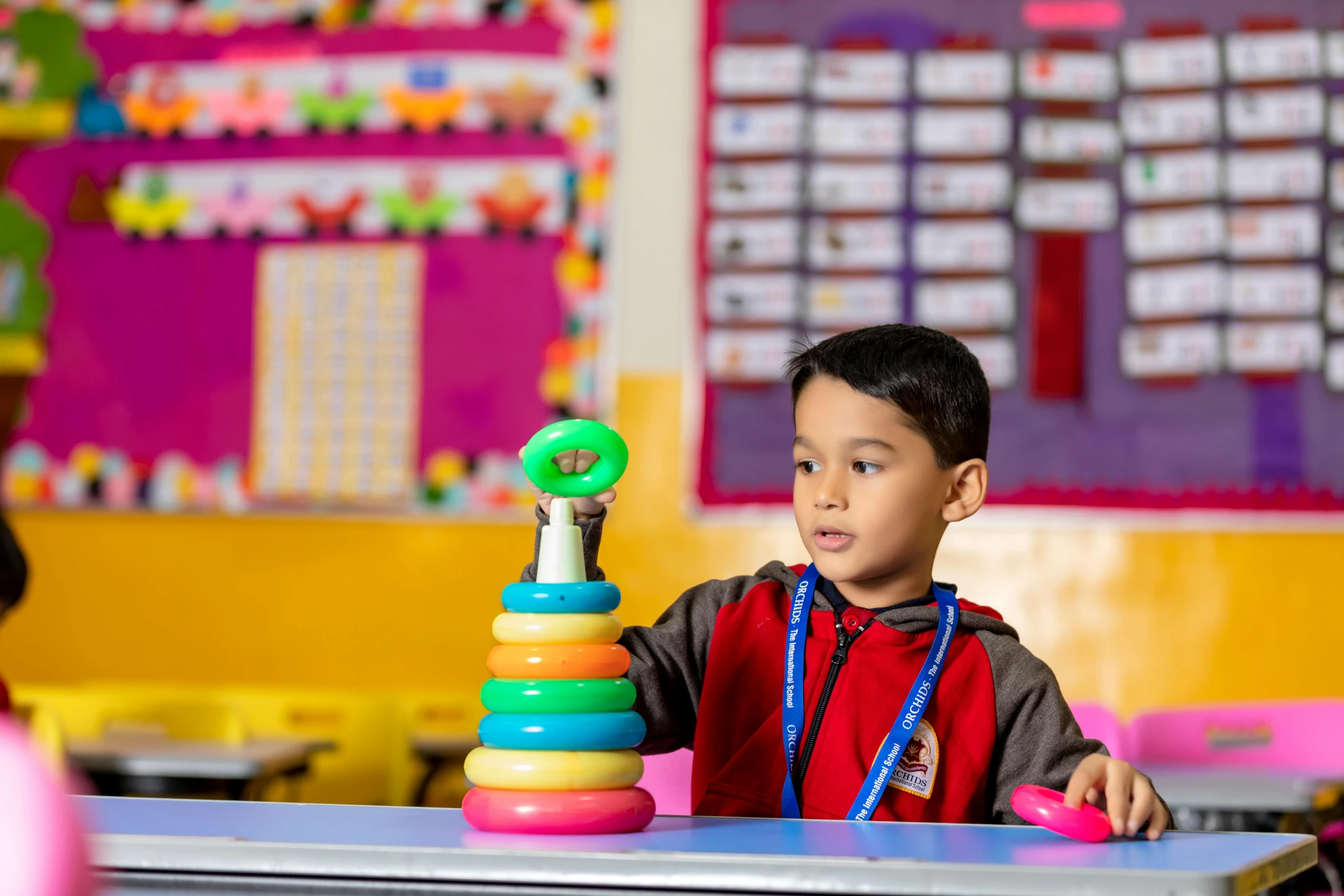 a child plays with toy stacking in a classroom