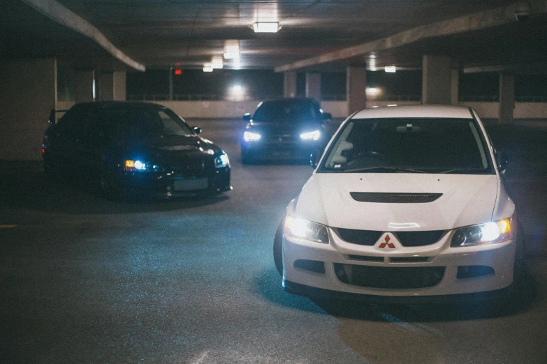 two cars are sitting parked in the parking garage