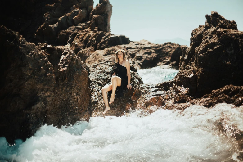 a woman standing on top of a pile of rocks