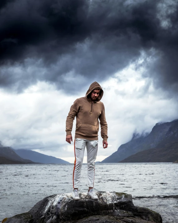 man standing on a rock at the edge of a body of water