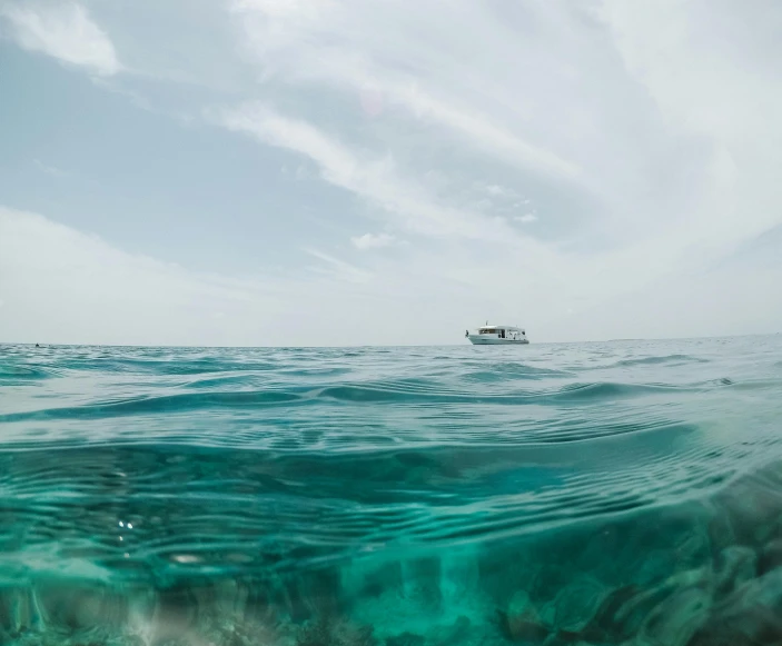 a boat is on the ocean near some green water