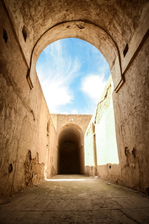 an arch over an alley leading to the sky