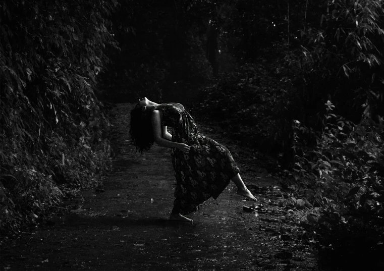 a woman carrying an item down a forest trail