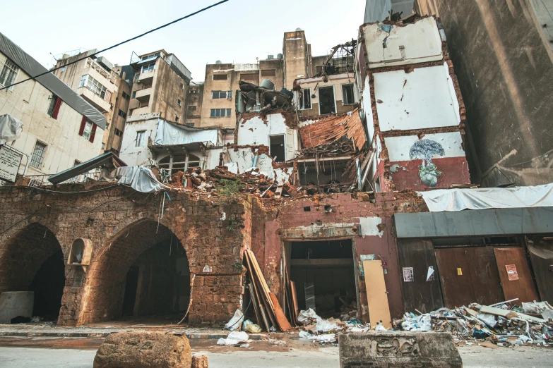 a crumbling old brick building with graffiti and other crumbling buildings