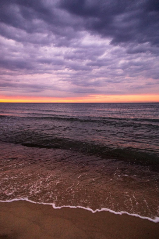 an ocean with waves in it and clouds