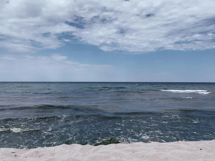 a boat out on the water is approaching the beach