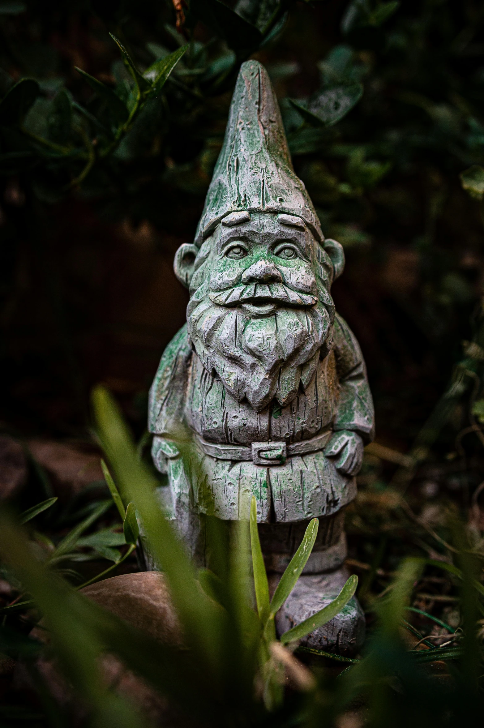 a statue of a gnome is sitting in the grass