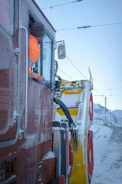 a worker in orange jumps off the side of a train car