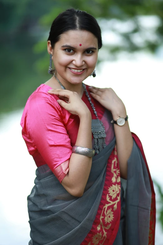 a woman posing in an indian dress wearing a celet