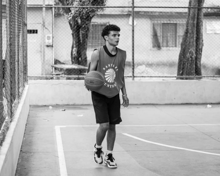 a young man is playing basketball outside on a court