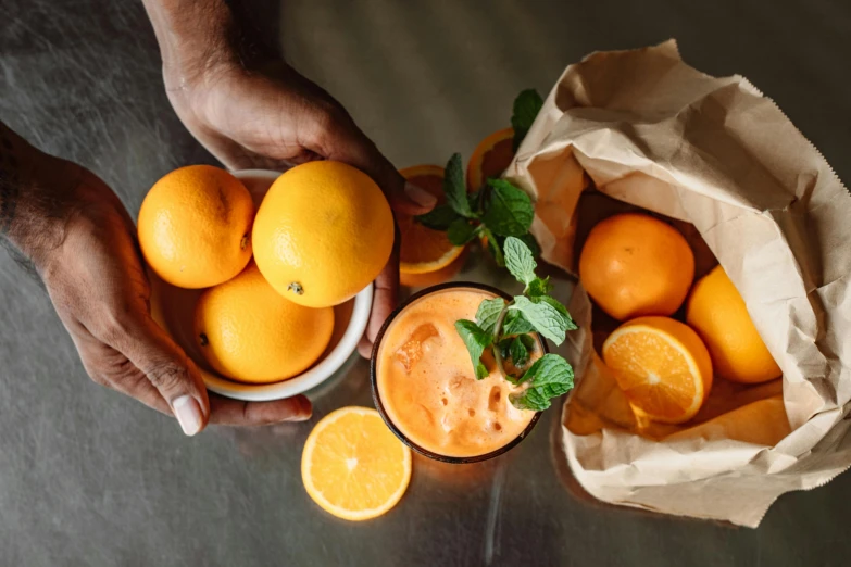 there are oranges that are in the basket with a drink