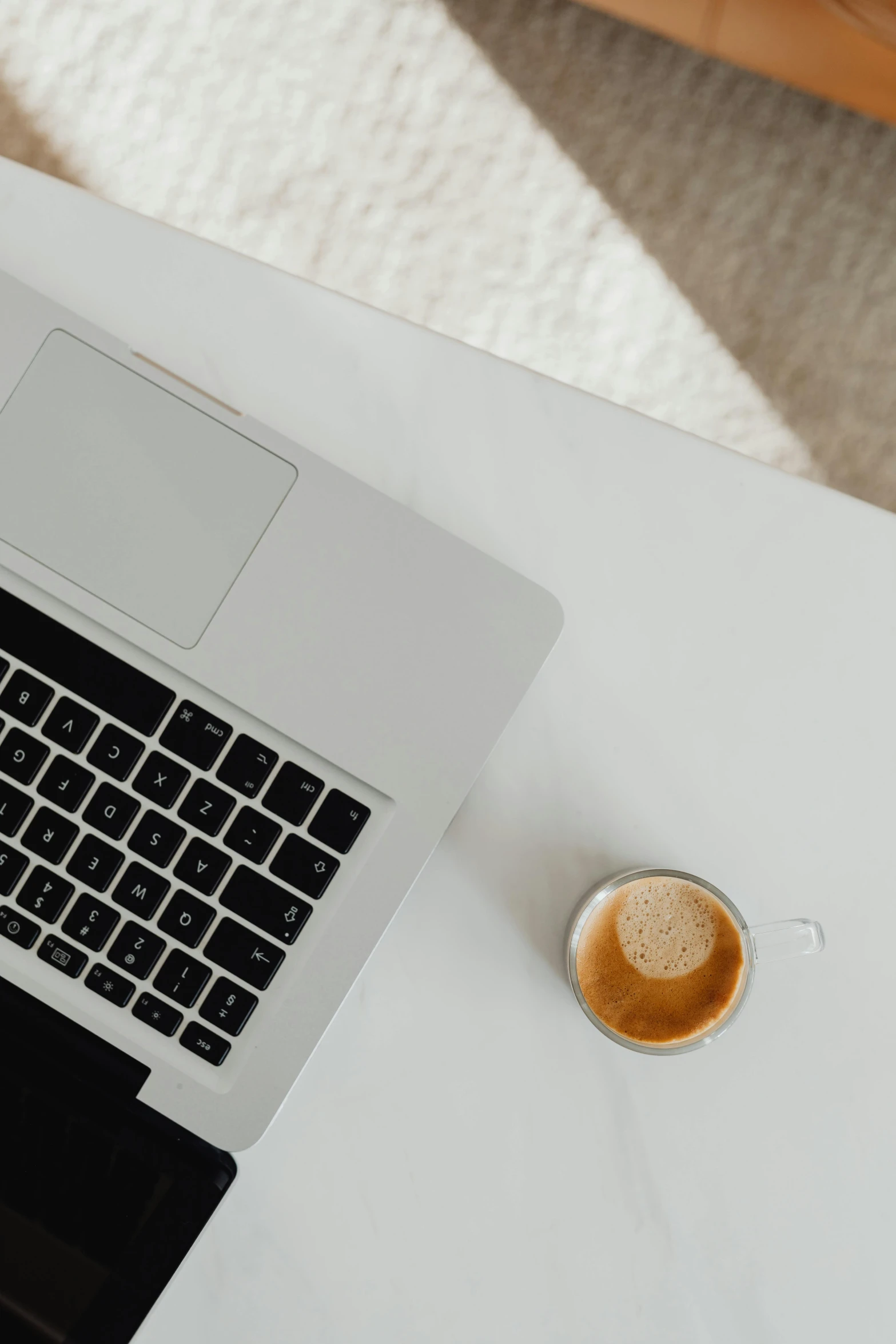 a coffee mug sits on a desk beside an open laptop