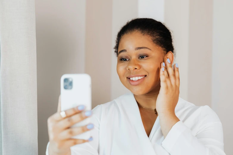 a beautiful young woman holding a cell phone taking a picture