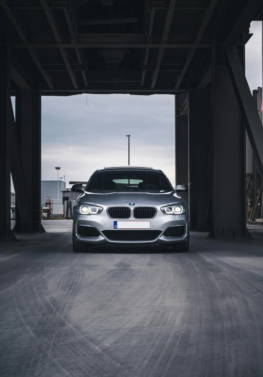 the modern car is parked underneath the very large structures