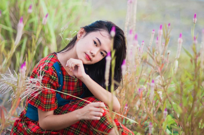 a woman in a plaid dress is posing for a portrait