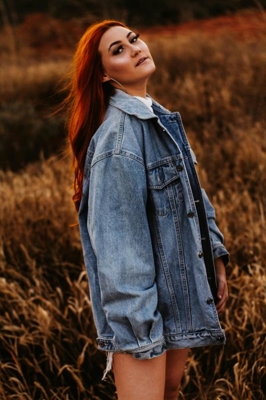 a woman with red hair is standing in a field